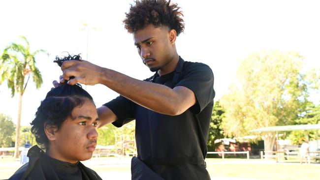 Wayne Api, 22, cuts a local boy's hair as part of the Fresh Start Academy program. Picture: Isaac McCarthy