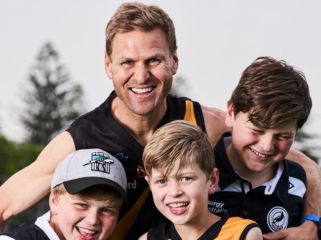 Kane Cornes poses for a picture with his sons, Raph, 11, Sonny, 9 and Eddy, 13 at Glenelg Football Club, ahead of the grand-final on Sunday, Thursday, Sept. 19, 2019. Picture: MATT LOXTON [Kane is recovering from an injury and didn't want to any big tackles]