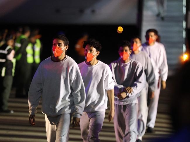 Venezuelan migrants deported from US Naval Station Guantanamo Bay walk down from the Venezuelan Conviasa Airlines plane as they arrive in Venezuela. Picture: AFP