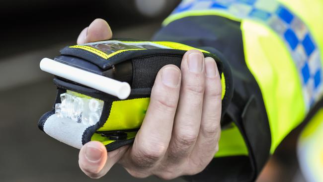 Belfast, Northern Ireland. 24 Nov 2016 - A police officer holds a roadside breathalyser alcohol breath test after taking a sample from a driver.