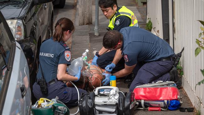 Paramedics treat a man near Richmond West Primary. Picture: Jason Edwards