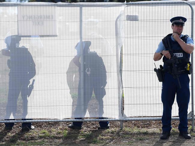 A police officer stands guard outside the burial ground where funerals for two victims are taking place today. Picture: William West/AFP