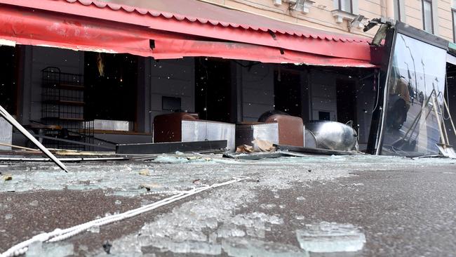 Municipal workers clean the debris in the aftermath of the cafe bomb blast. Picture; AFP.