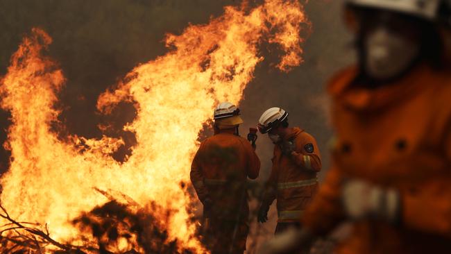 Tasmania Fire Service personnel put out a spot fire threatening a home on Donnelleys Rd, Geeveston. Picture: LUKE BOWDEN