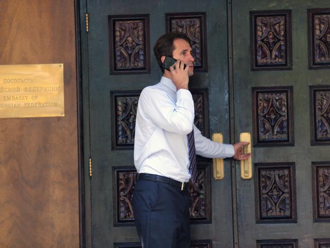 A Russian staff member chats on the phone inside the secured grounds at the embassy in Canberra today.