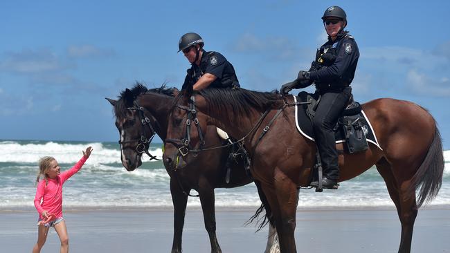 Senior Constable Dave Masters (centre) with police horse Manny and Roy Mientjes with 'police horse Arnie on patrol at Maroochydore Beach.