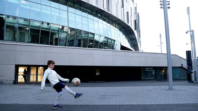 A young fans plays football outside Tottenham Hotspur Stadium before the match between Spurs and Fulham which was postponed as a Covid-19 precaution