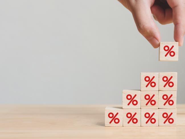 Interest rate financial and mortgage rates concept. Hand putting wood cube block increasing on top with icon percentage symbol upward direction. per cent generic.