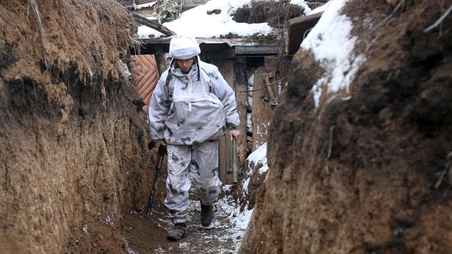 A Ukrainian serviceman walks along a snow covered trench on the frontline with the Russia-backed separatists near Verkhnetoretskoye village, in the Donetsk region. Picture: AFP