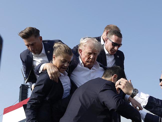 TOPSHOT - BUTLER, PENNSYLVANIA - JULY 13: Republican presidential candidate former President Donald Trump pumps his fist as he is rushed offstage during a rally on July 13, 2024 in Butler, Pennsylvania. Butler County district attorney Richard Goldinger said the shooter is dead after injuring former U.S. President Donald Trump, killing one audience member and injuring another in the shooting.   Anna Moneymaker/Getty Images/AFP (Photo by Anna Moneymaker / GETTY IMAGES NORTH AMERICA / Getty Images via AFP)