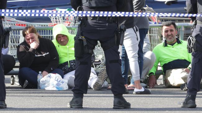 Police watch over distressed loved ones at the scene. Picture: David Caird