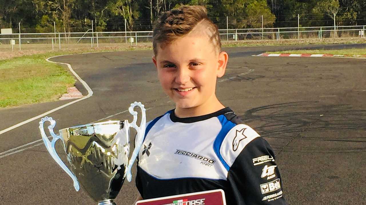 Max Acquasanta shows off his trophy and maroon winner's number plate after winning the State Cup in Cadet 12. Picture: Contributed