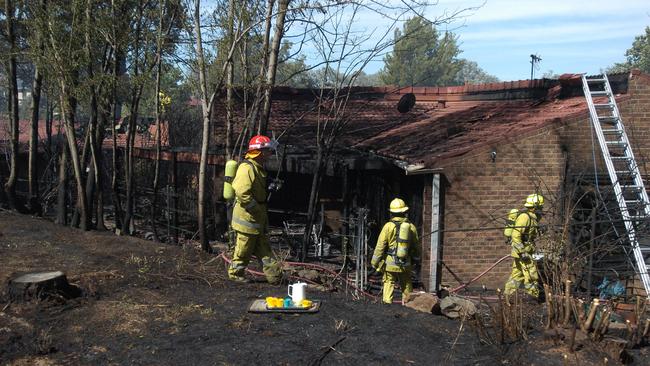 Firefighters inspect a destroyed unit block in the Canberra suburub of Yarralumla on December 29, 2005. Picture: Kym Smith