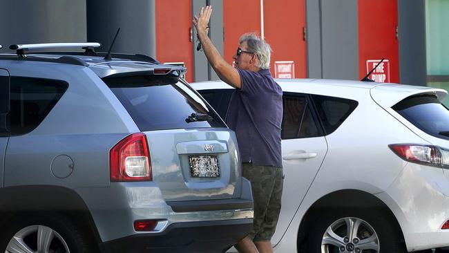 A man waves to a family member at the Airport Novotel Hotel in Brisbane after passengers were taken from a flight from Bali to the hotel for quarantine in Brisbane, Sunday, March 29, 2020. Overseas arrivals are now forced to be quarantined in hotels in a bid to stop the spread of COVID-19 (AAP Image/Dave Hunt) NO ARCHIVING