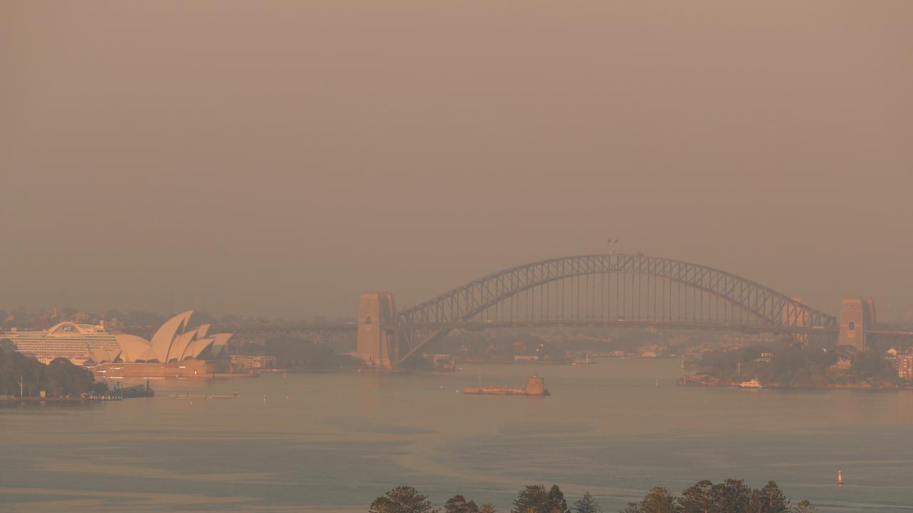 Smoke choking Sydney Harbour at dawn. Picture: John Grainger.