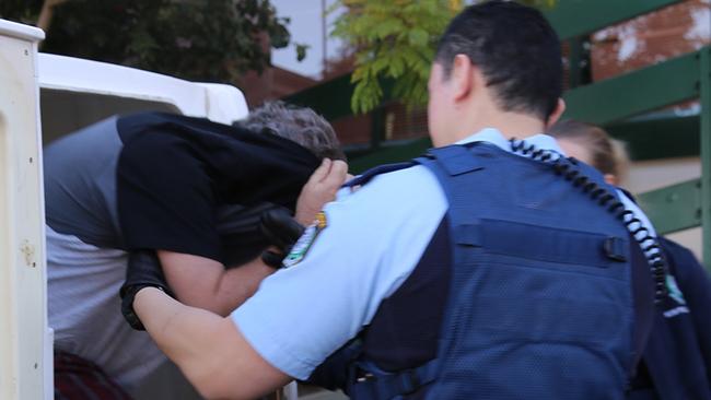 Gregory Richardson is taken from a police vehicle after his early-morning arrest. Picture: NSW Police