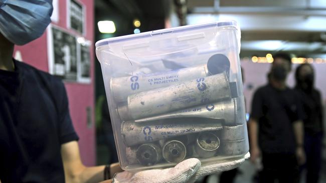 A protester displays a container with empty tear gas canisters at the site where student Chow Tsz-Lok fell. Picture: AP