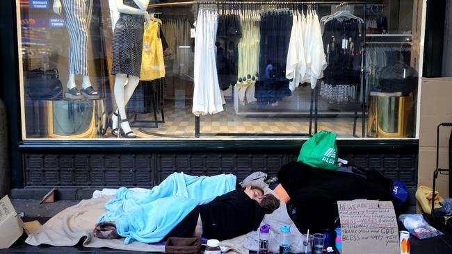 Two homeless people camped outside the QVB in the city. Picture: John Grainger