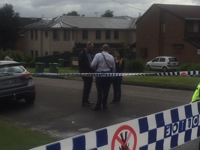 Police speak with a witness outside Carmichael's Corner Store. Picture: Richard Noone