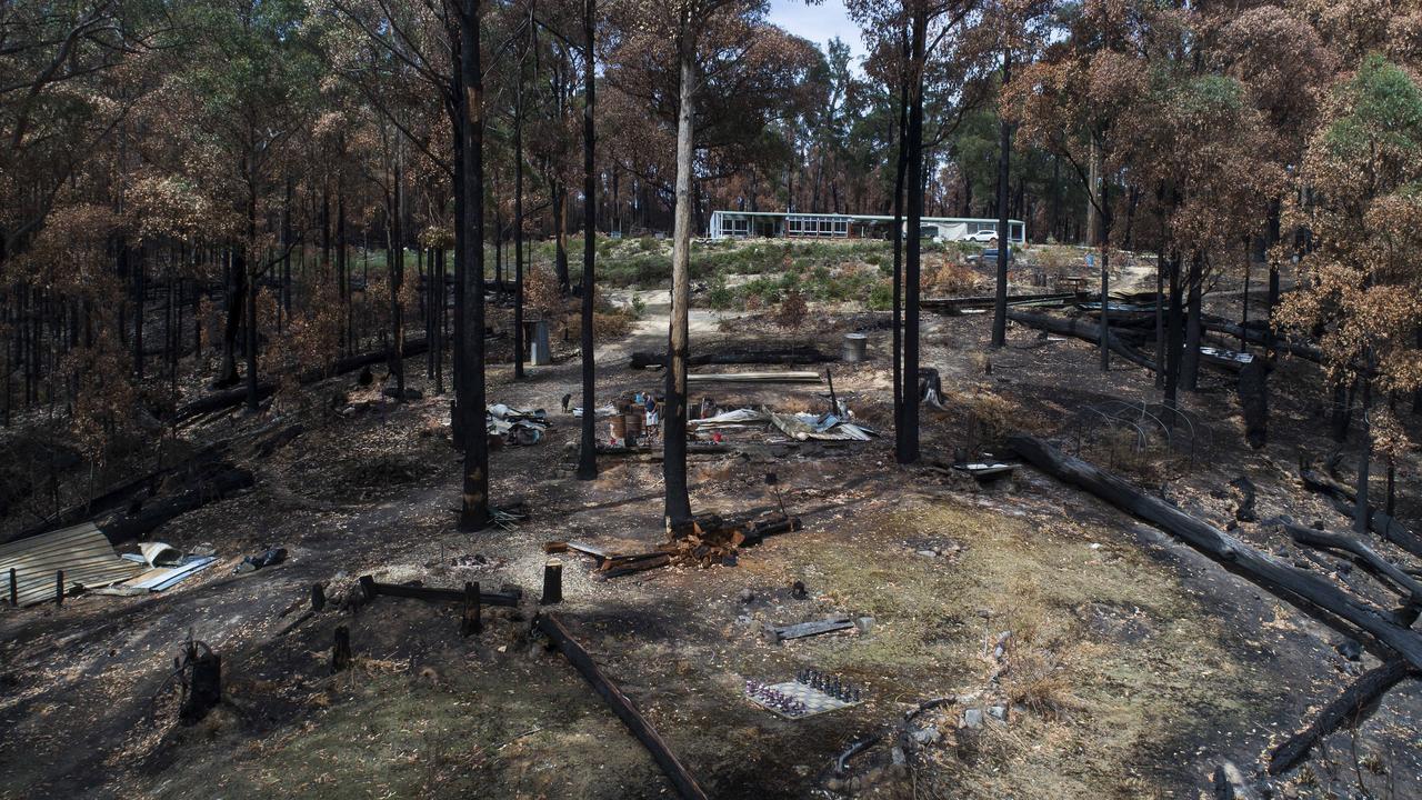 Dale "Hairy Man" Fullard cleans up at the site of his home on Southwood Rd that was destroyed in the bushfire.