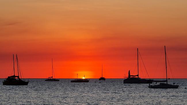 Sailboats bob on the horizon, silhouetted against a dramatic sunset at Bundilla Beach. Picture: Zoe Cooper