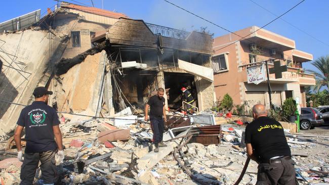 Rescuers inspect the debris at the site of an overnight Israeli strike on a pharmacy in the southern Lebanese village of Akbiyeh on Tuesday. Picture: AFP