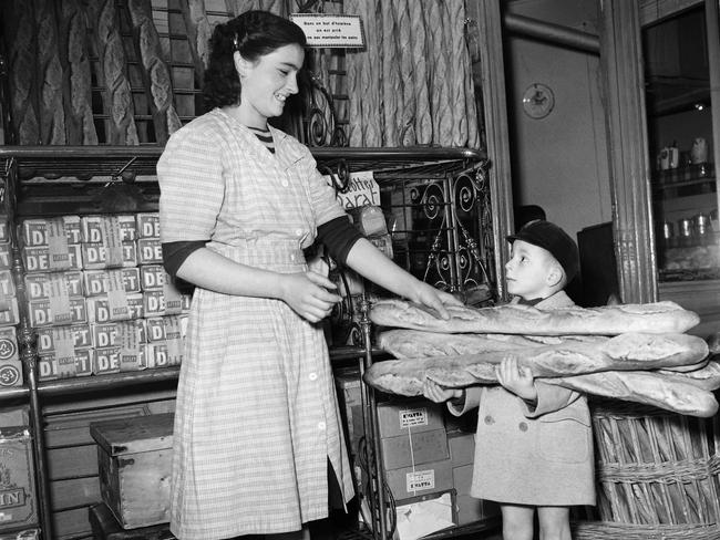 (FILES) In this file photo taken on November 24, 1949, a little boy buys baguette bread, as Parisians stock up on bread for two days in preparation for the general bakers' strike in Paris. - The French baguette was given UNESCO World Heritage status on November 29, 2022, as the UN agency granted "intangible cultural heritage status" to the tradition of making the baguette and the lifestyle that surrounds them. (Photo by AFP)