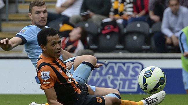 Manchester City's Edin Dzeko, rear, beats Hull City's Liam Rosenior to score his side's third goal during their English Premier League match at the KC Stadium, Hull England Saturday Sept. 27, 2014. (AP Photo/Anna Gowthorpe/PA) UNITED KINGDOM OUT NO SALES NO ARCHIVE