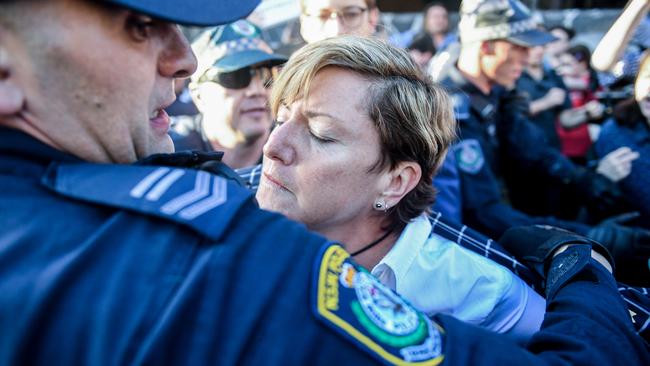 Police usher Christine Foster to safety amid the protest. (Pic: AAP)