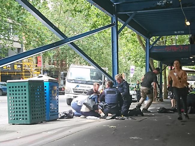 Helping a victim just moments after the rampage. Picture: AAP