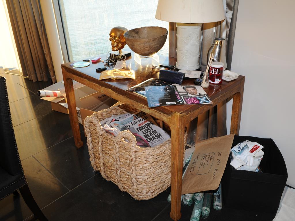 A lamp table in one of John Ibrahim’s rooms with a copy of his autobiography and newspaper including The Sunday Telegraph.