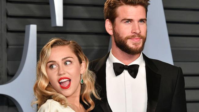 BEVERLY HILLS, CA - MARCH 04: Miley Cyrus (L) and Liam Hemsworth attend the 2018 Vanity Fair Oscar Party hosted by Radhika Jones at Wallis Annenberg Center for the Performing Arts on March 4, 2018 in Beverly Hills, California.   Dia Dipasupil/Getty Images/AFP == FOR NEWSPAPERS, INTERNET, TELCOS & TELEVISION USE ONLY ==