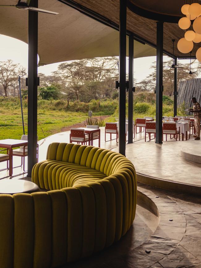 A lounge area is brightened with a yellow sofa and red chairs.