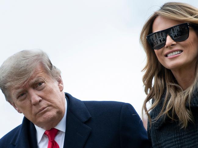 US President Donald Trump and First Lady Melania Trump walk from Marine One as they return to the White House on December 31, 2020, in Washington, DC. (Photo by Brendan Smialowski / AFP)