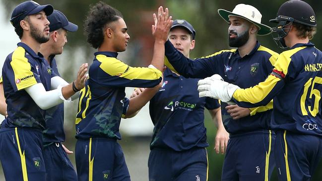 Aryan Sharma (third left) of Plenty Valley celebrates with teammates last season after taking a wicket. Photo: Hamish Blair