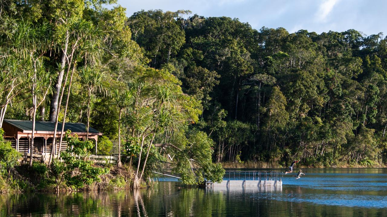 Family jumping into Lake Eacham from the jetty. Photo: TNQ