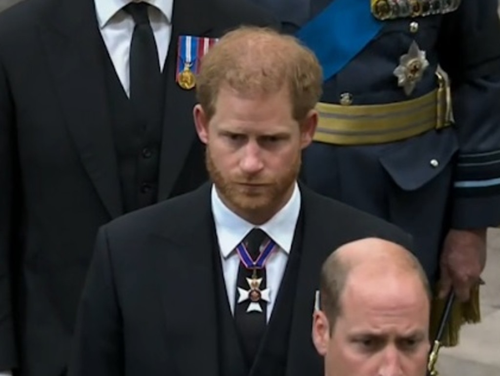 A sad-looking William and Harry enter Westiminster Abbey.