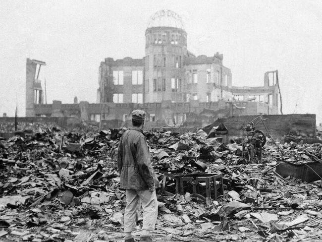 FILE - In this Sept. 8, 1945 file photo, an allied correspondent stands in the rubble in front of the shell of a building that once was a exhibition center and government office  in Hiroshima, Japan, a month after the first atomic bomb ever used in warfare was dropped by the U.S. on Aug. 6, 1945. (AP Photo/Stanley Troutman, File)