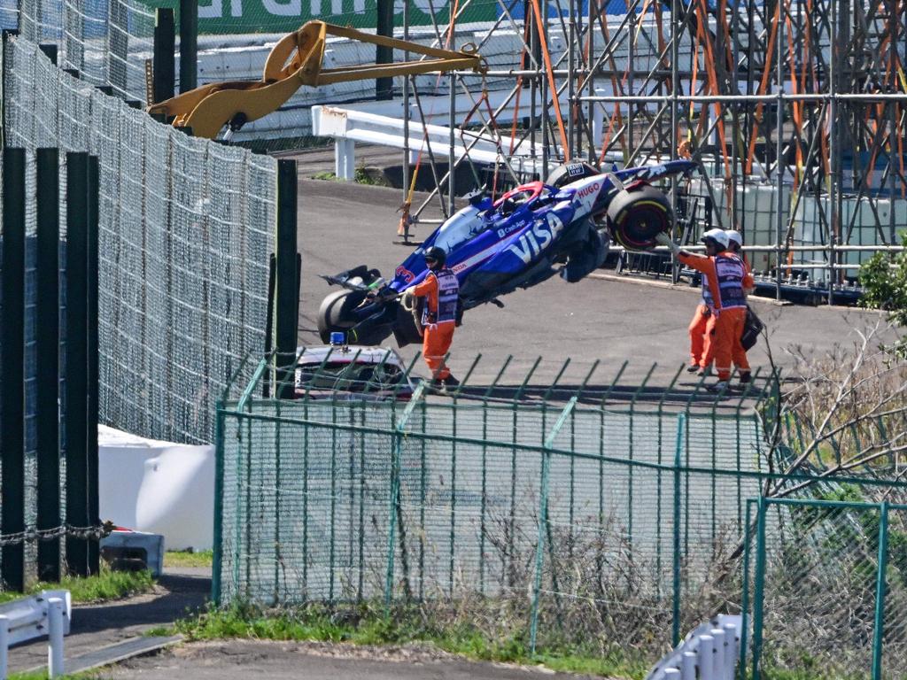 Officials remove the car of RB's Australian driver Daniel Ricciardo from the track after he crashed out at the start of the Formula One Japanese Grand Prix race at the Suzuka circuit in Suzuka, Mie prefecture on April 7, 2024. (Photo by Yuichi YAMAZAKI / AFP)