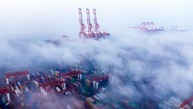 Ships and containers are shrouded in fog at the Yangshan Deepwater Port in Shanghai, which faces uncertainty as global trade tensions mount. Picture: AFP/Getty Images