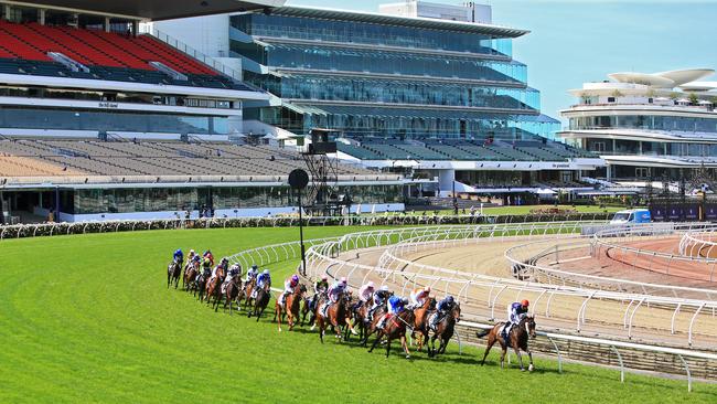 Empty stands tower over the track as Twilight Payment leads the pack on the first turn during the running of the 2020 Melbourne Cup at Fleming Racecourse. Picture: Aaron Francis