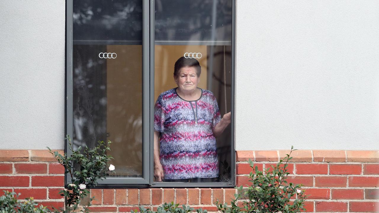 A resident looks out her window at Arcare Maidstone Aged Care after a resident tested positive. Picture: David Crosling