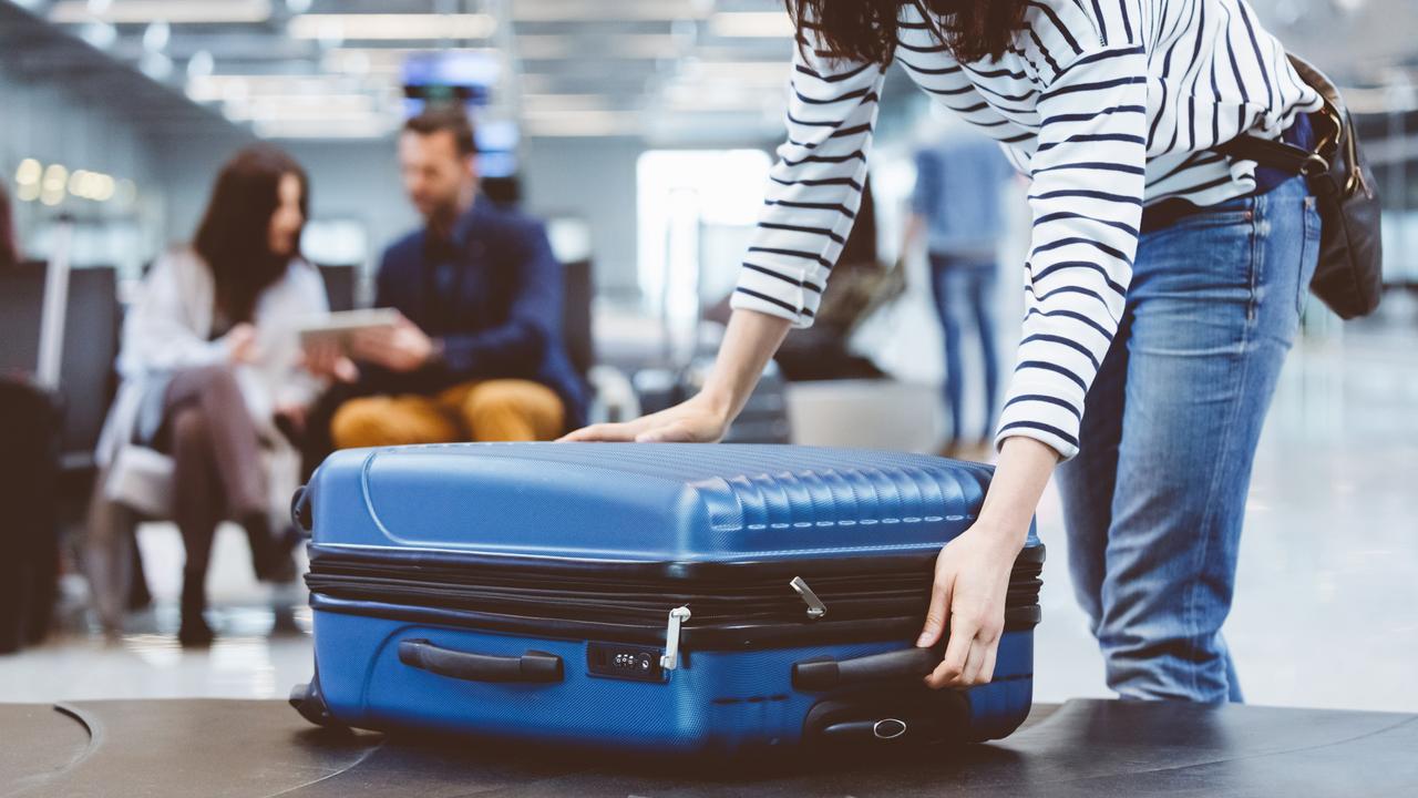 Young woman passenger collecting her luggage from conveyor belt. Female traveller picking up suitcase from baggage claim line in airport terminal. Escape 14 January 2024 Kendall Hill Photo – iStock