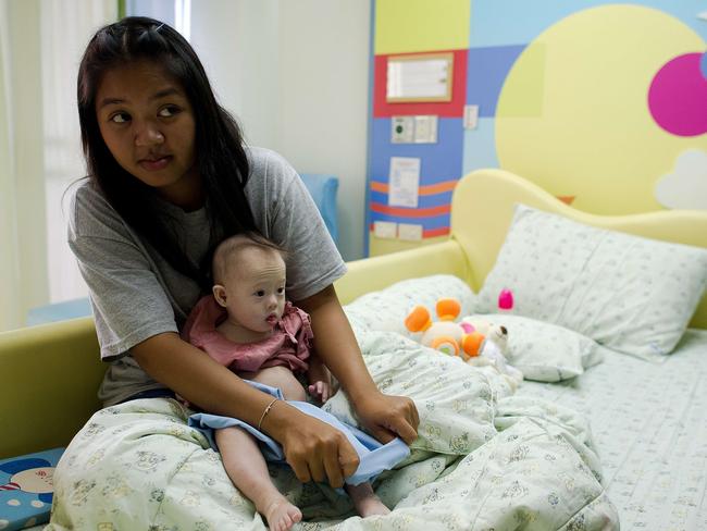Thai surrogate mother Pattaramon Chanbua holds her baby Gammy, born with Down syndrome. AFP PHOTO / Nicolas ASFOURI