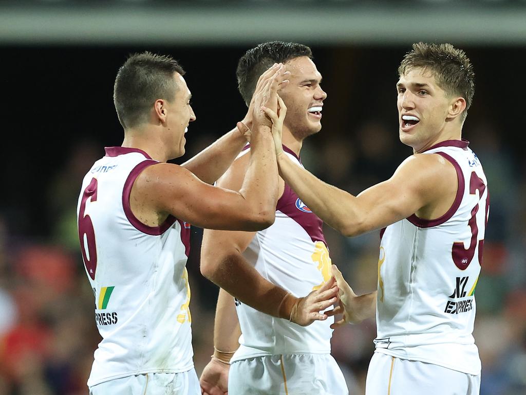 Zac Bailey (right) celebrates a QClash goal with Lions teammates Hugh McCluggage (left) and Cam Rayner. Picture: Chris Hyde/Getty Images