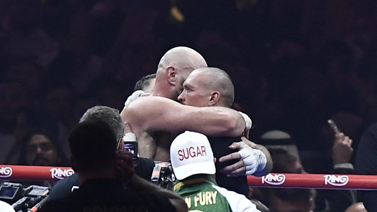 Usyk and Fury embrace in the ring after their heavyweight world championship rematch. (Photo by AFP)