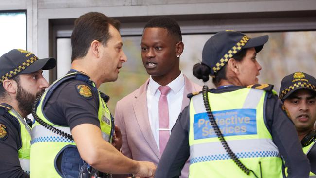 Protective Service Officers speak to Nelly Yoa outside court today. Picture: AAP Image/Erik Anderson