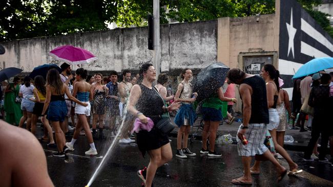 Fans try to cool themselves while queuing before the concert. Picture: Tercio Teixeira/AFP