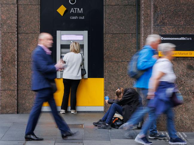 SYDNEY, AUSTRALIA - NewsWire Photos MAY 10 2024. GENERIC. A woman begs for money next to a Commonwealth Bank ATM in Sydney. Economy, cost of living, budget, poverty, homeless, banking. Picture: NCA NewsWire / Max Mason-Hubers