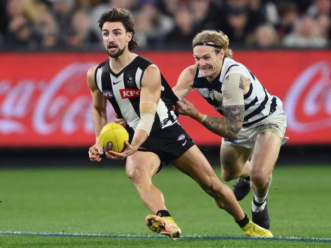 MELBOURNE, AUSTRALIA - SEPTEMBER 03: Josh Daicos of the Magpies handballs whilst being tackled by Tom Stewart of the Cats during the AFL First Qualifying Final match between the Geelong Cats and the Collingwood Magpies at Melbourne Cricket Ground on September 03, 2022 in Melbourne, Australia. (Photo by Quinn Rooney/Getty Images)